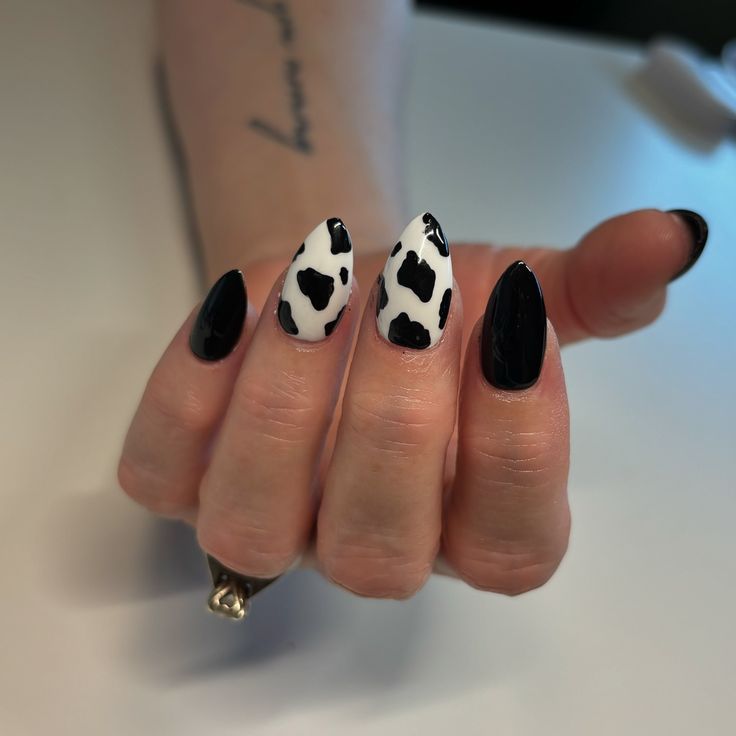 Trendy Cow-Print Nail Design: Bold Black and White with Pointed Shapes for a Playful Statement.