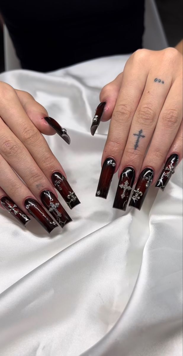 Elegant Gothic-Inspired Dark Nail Design with Deep Burgundy Base and Silver Embellishments.