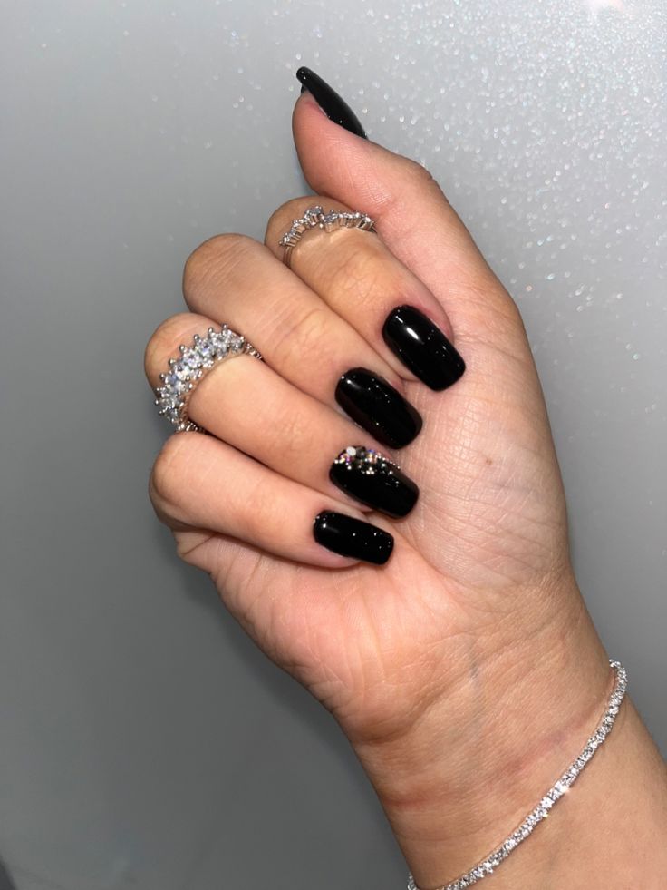 Elegant Black Nail Design with Glossy Finishes and Glamorous Accents.