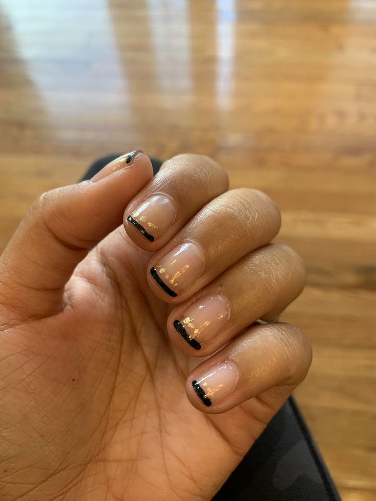 Chic Minimalist Nude Nail Design with Black Tips and Gold Accents