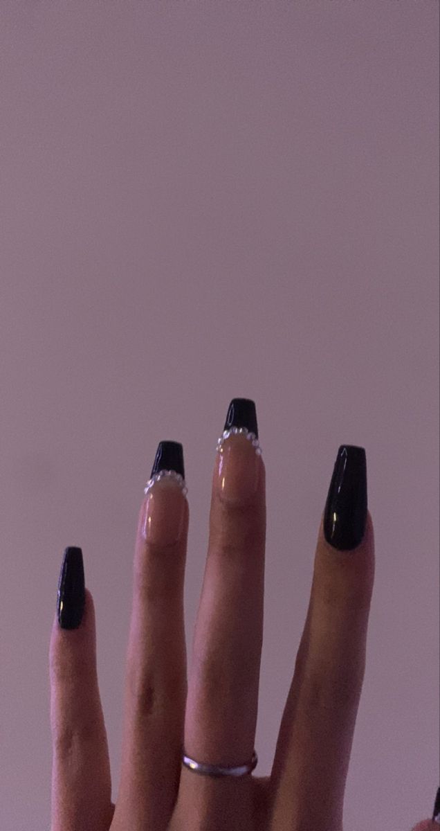 Sophisticated Black and Nude Nail Design with Intricate Details and Sparkling Rhinestones.