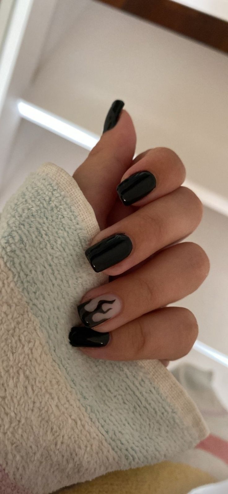 Edgy Elegance: Stylish Black Nail Design with Glossy-Matte Finish and Flame Accent.