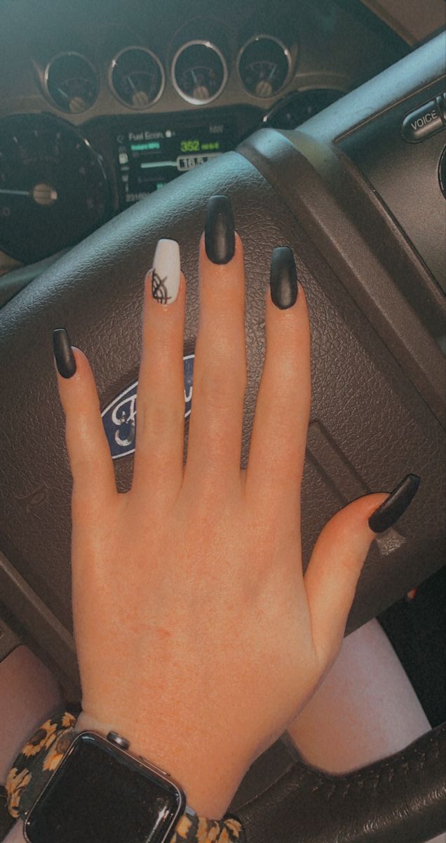 Chic Matte Black and White Nail Art with Playful Spider Web Accent