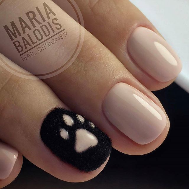 Whimsical Nail Design: Soft Nude and Textured Black with Playful Paw Print Accent.