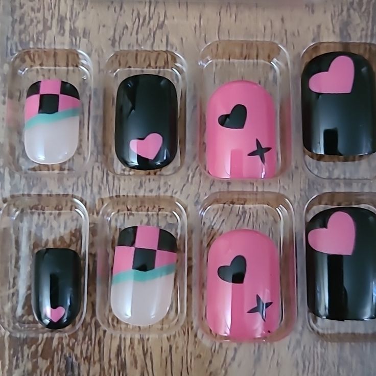 Playful Geometric and Heart-Inspired Nail Designs in Bold Black, Pink, and White.