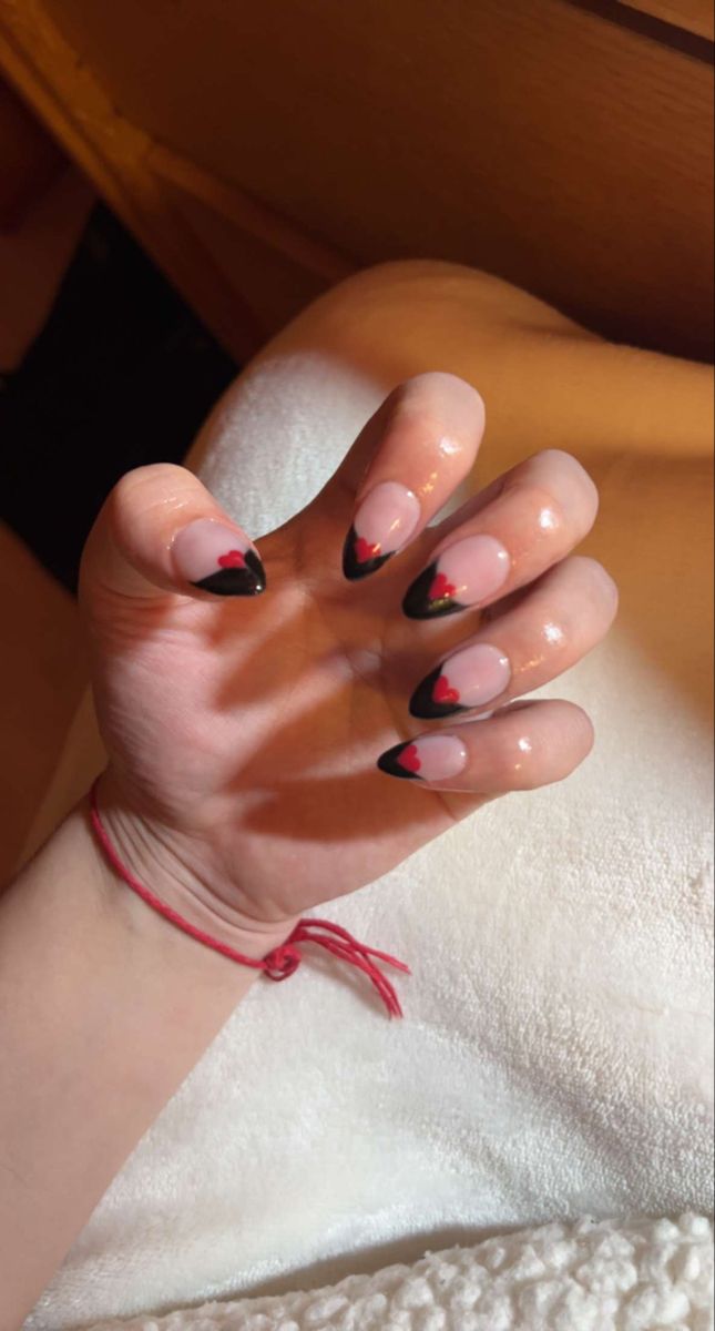 Chic Nude and Black Nail Design with Playful Red Heart Accents