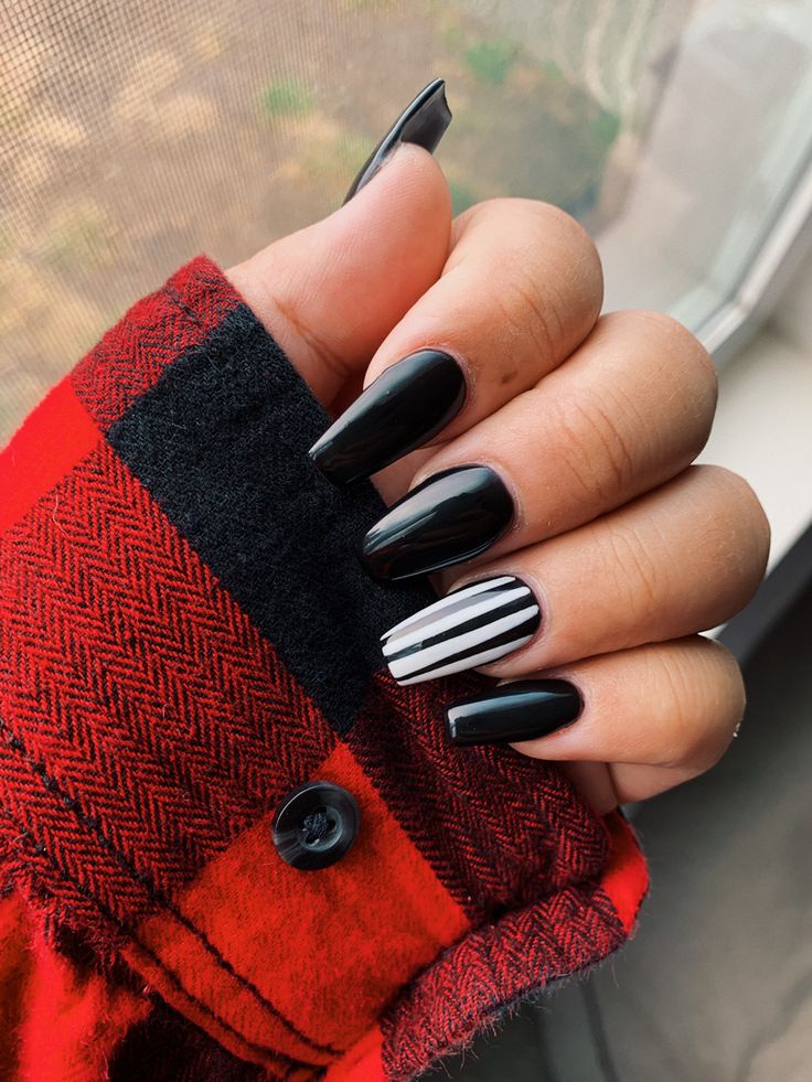 Chic Black Nails with Bold White Striped Accent for a Fashionable Statement.