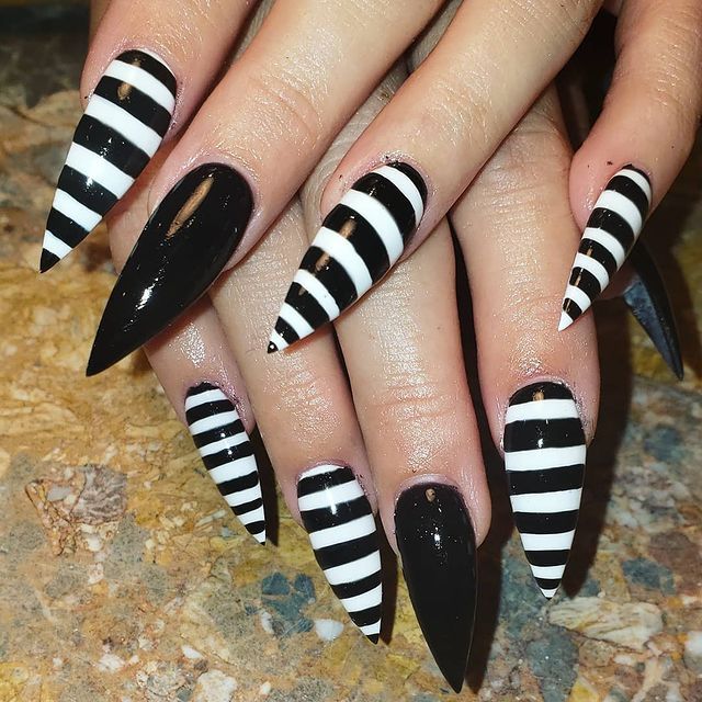 Dramatic Stiletto Nail Design with Glossy Black and Bold White Stripes