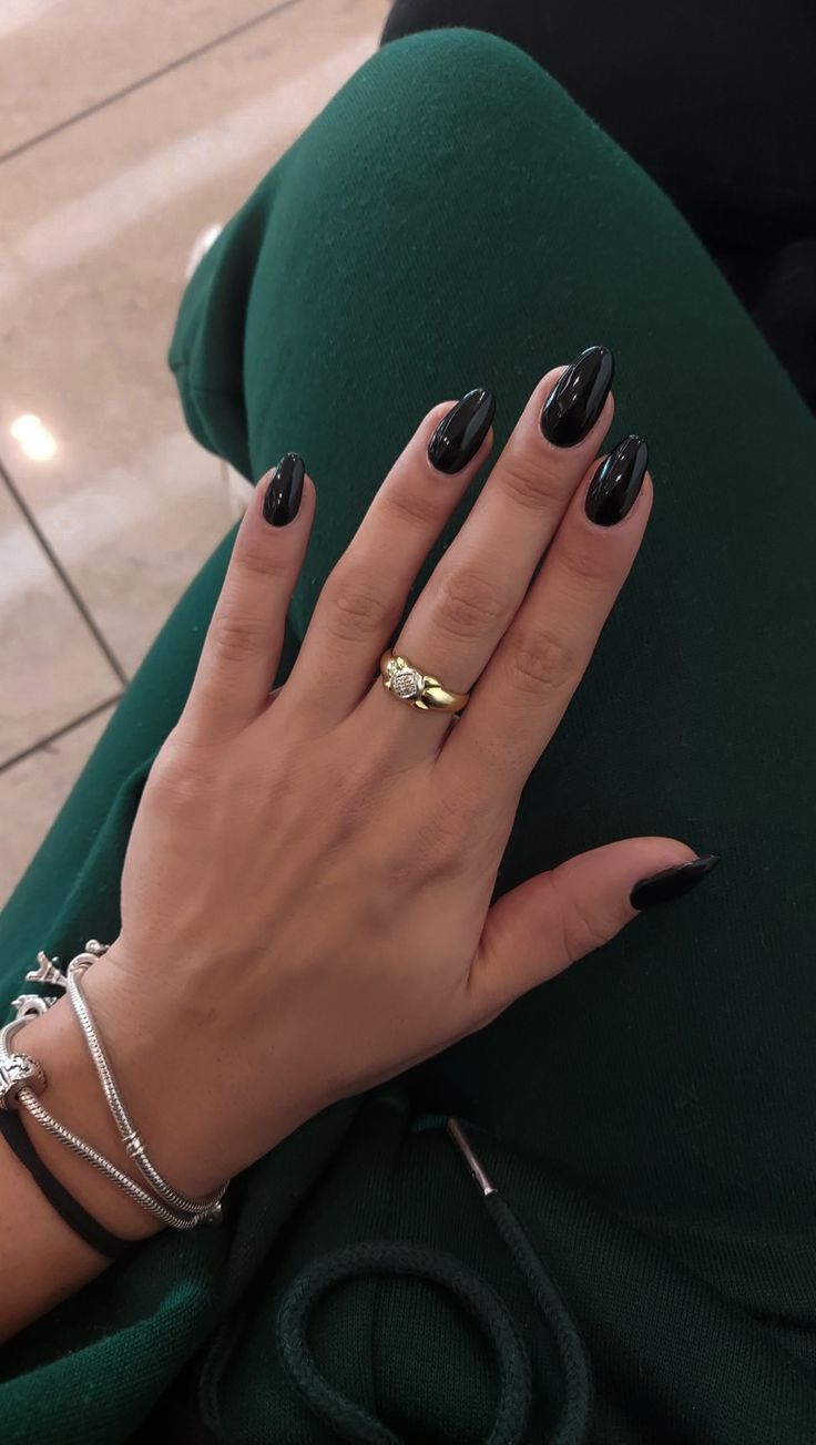 Elevate Your Style with Elegant High-Gloss Black Almond Nails and Gold Accents.