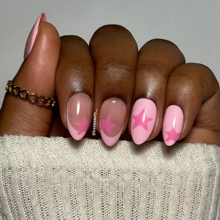 Whimsical Pink Nail Design: A Chic Blend of Solid and Translucent Finishes with Playful Star Accents.