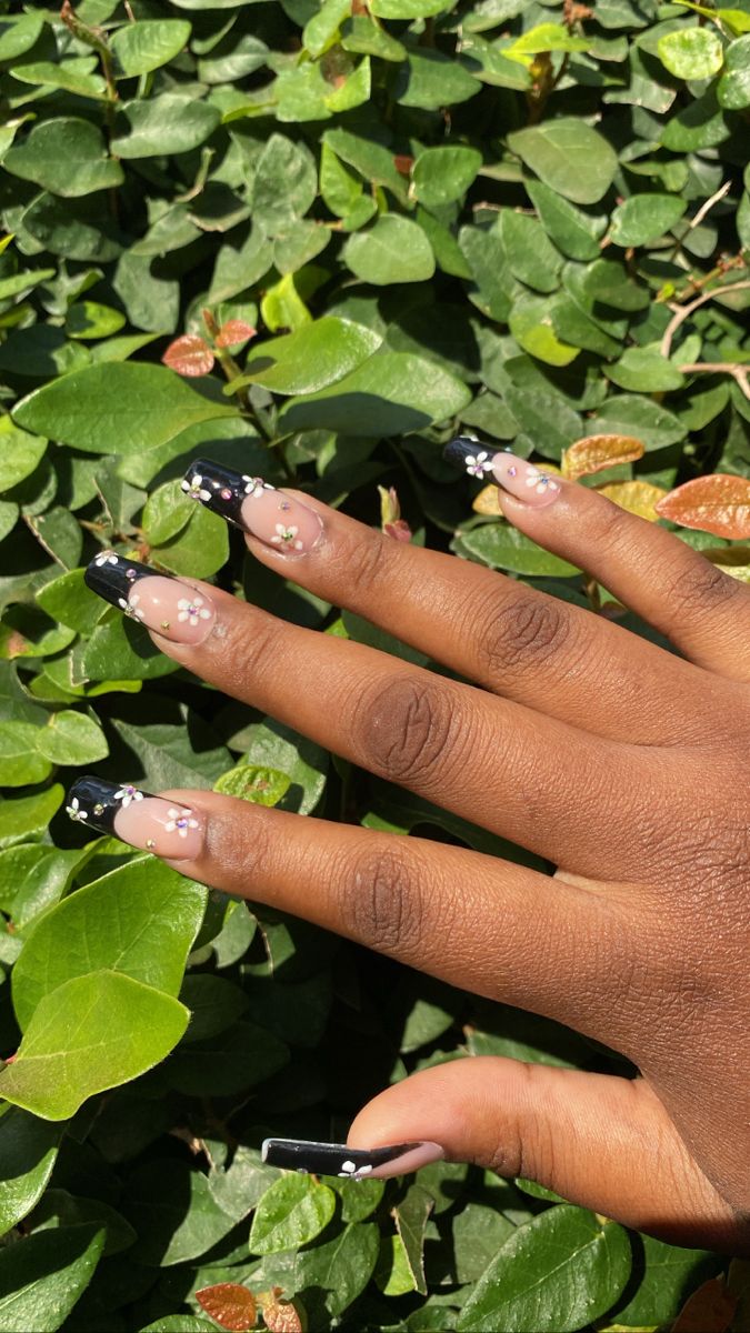 Chic Nude and Black Nail Design with Feminine Floral Accents for Any Occasion