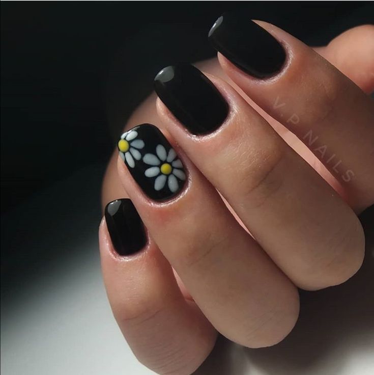 Chic Black Nail Design with Vibrant Daisy Accent for a Bold Statement.