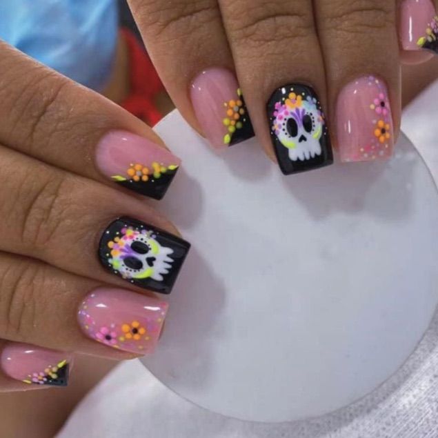 Playful Skull Motif Nail Design: Striking Pink and Black with Floral Accents.