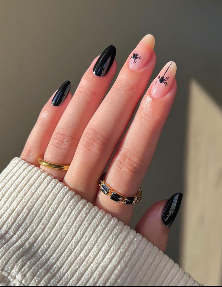 Elegant Black and Nude Nail Design with Playful Spider Motifs.