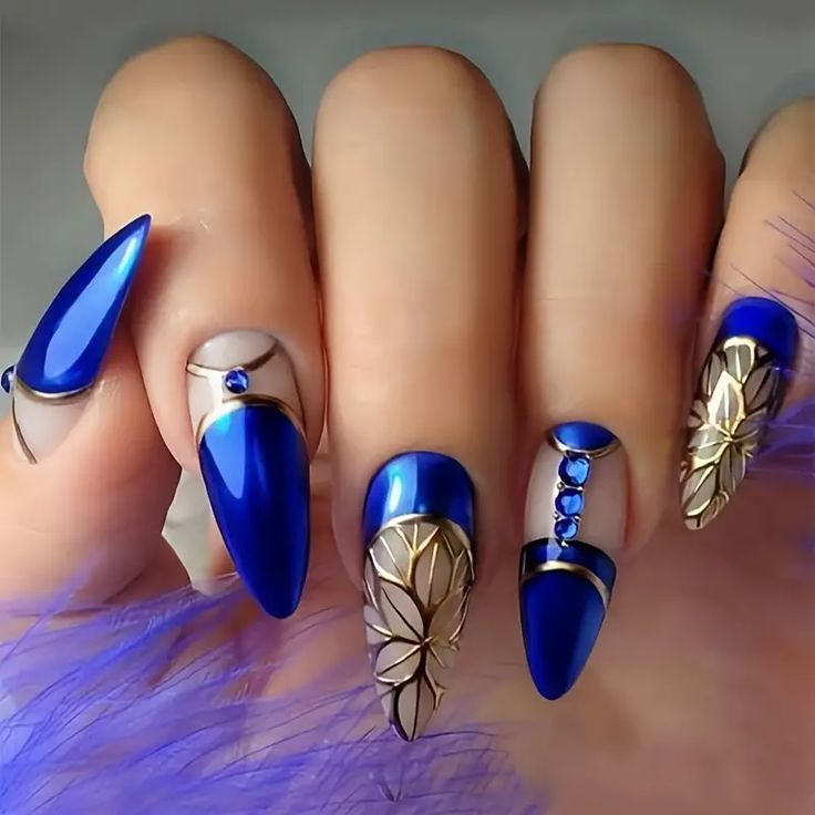 Elegant Bold Blue Nail Design with Almond and Stiletto Shapes, Gold Details, Gemstones, and Mixed Finishes.