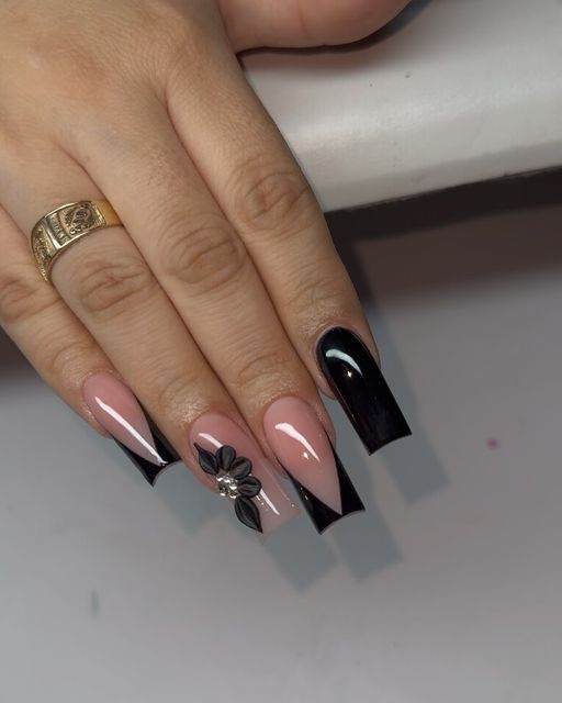 Chic French Tip Nail Design: Soft Pink and Bold Black with Whimsical Floral Accent.