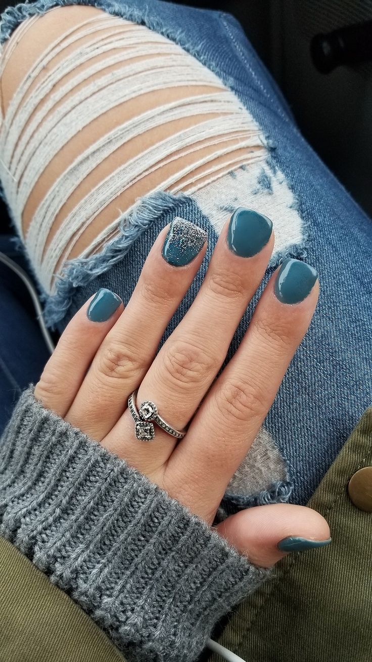 Chic Deep Teal Nail Design with Sparkling Accents Perfectly Complements Distressed Denim.