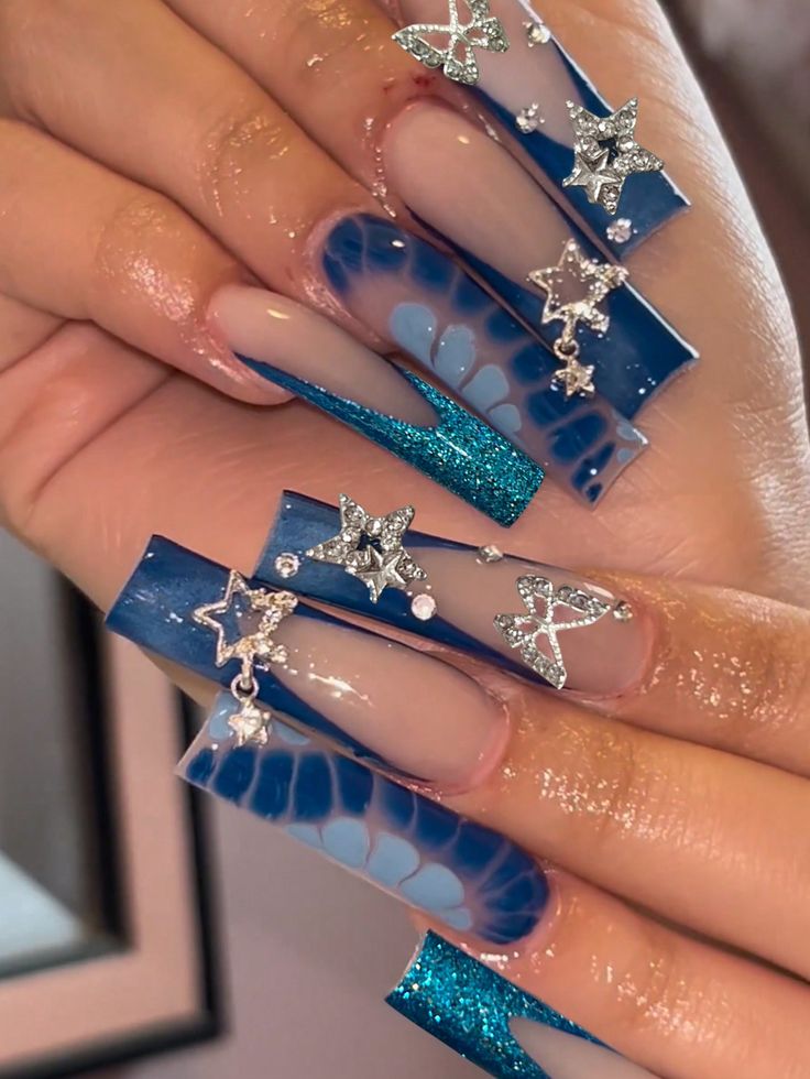 Striking Blue Marble Nail Design with Glitter Accents and Star Appliques