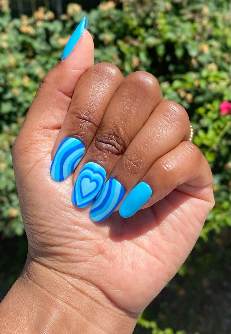 Vibrant Blue Nail Design with Artistic Heart Pattern and Glossy Finish.