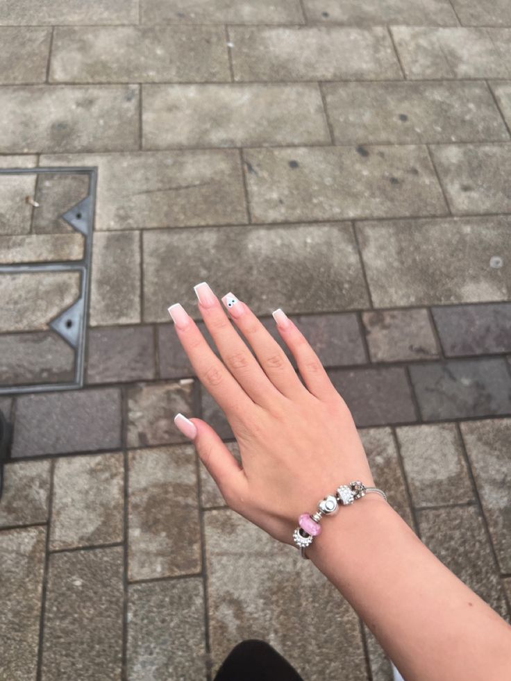 Chic Classic Nail Design with Polished Nude Base, White Tips, and Elegant Bracelet.