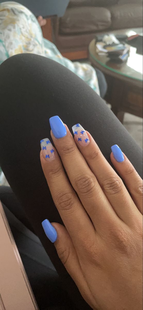 Trendy Vibrant Blue Nail Art with Creative Designs and Solid Tips.