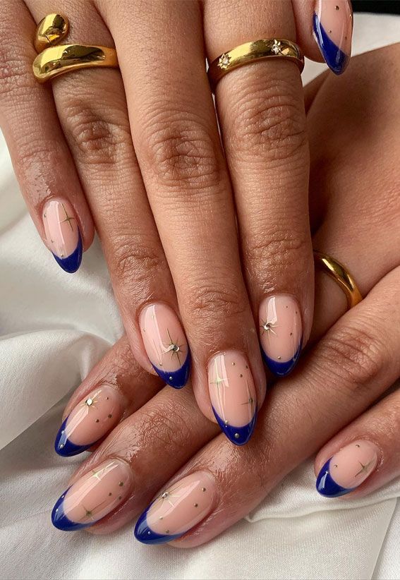 Chic Navy Blue-Tipped Nail Design with Nude Base and Gold Accents.