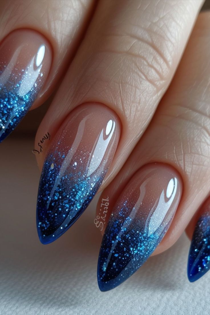 Elegant Deep Blue Gradient Nail Design with Glitter Accents for Any Occasion.