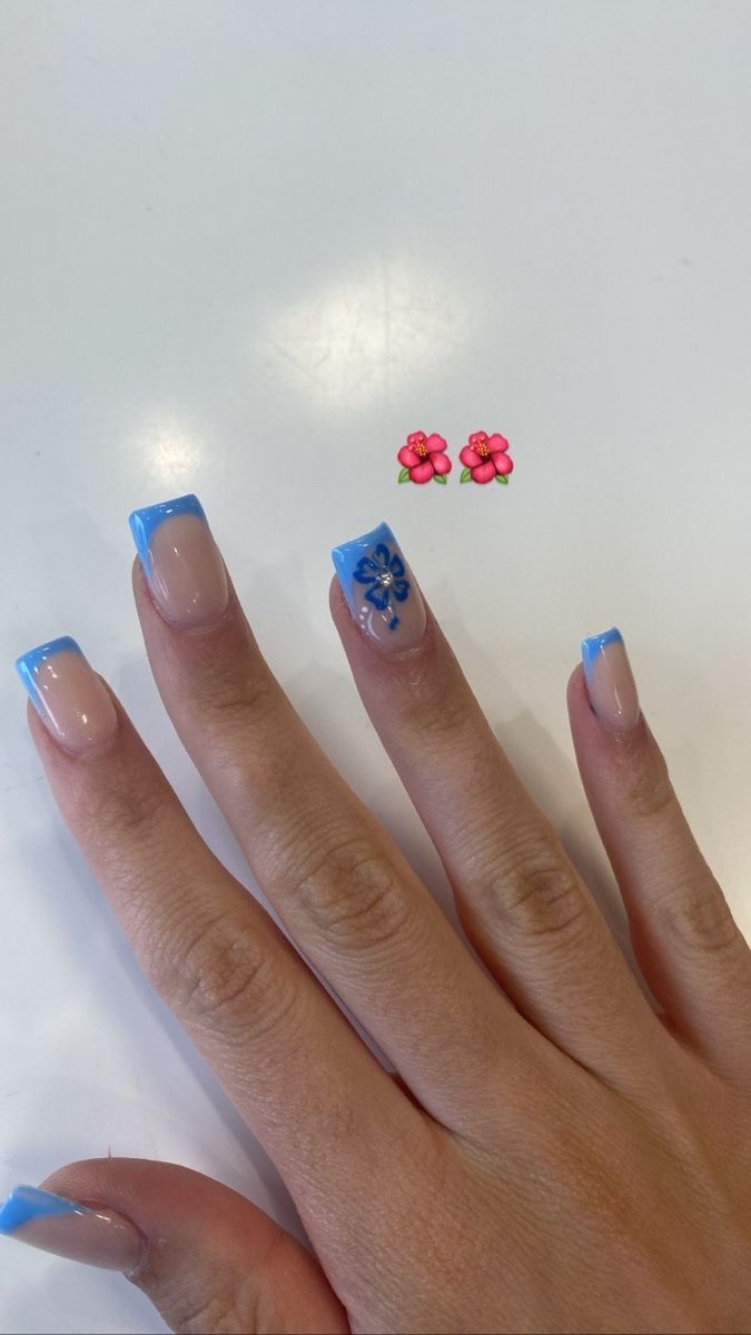 Chic Nail Design: Soft Nude Base with Vibrant Blue Tips and Playful Floral Accent.