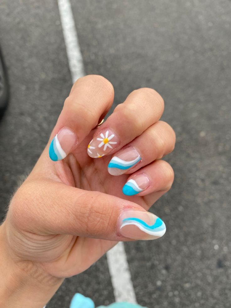 Playful Turquoise and White Swirl Nail Design with Delicate Daisy Accent.