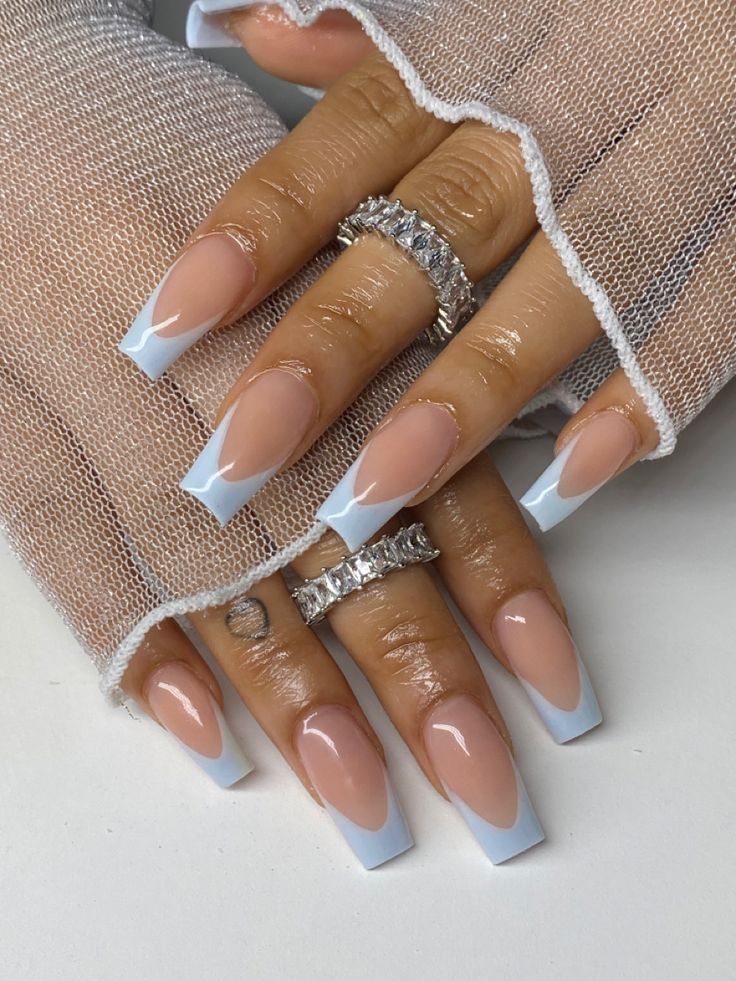 Sophisticated Nude and Baby Blue Nail Design with Glossy Finish and Shimmering Accents.