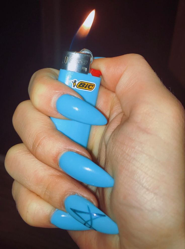 Bold Vibrant Blue Manicure with Geometric Artistry on Long Pointy Nails.