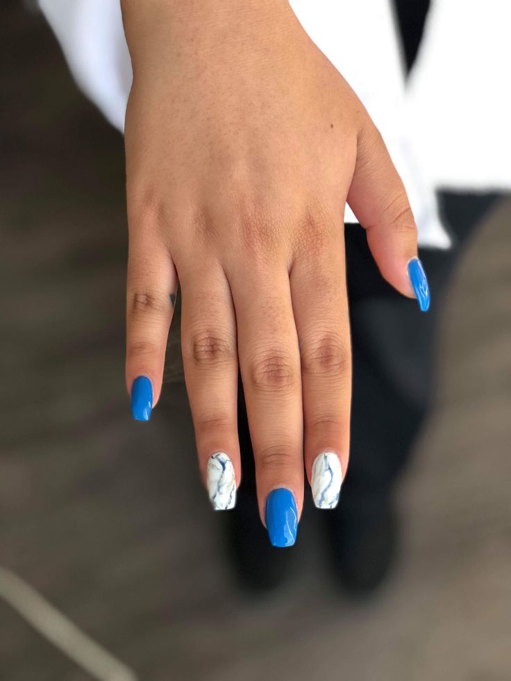 Chic Nail Design: Vibrant Blue Polish with Elegant Marble Accents