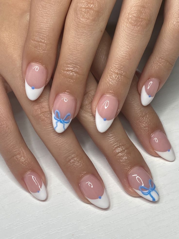 Chic French Tip Nail Design with Whimsical Blue Bow Accents.