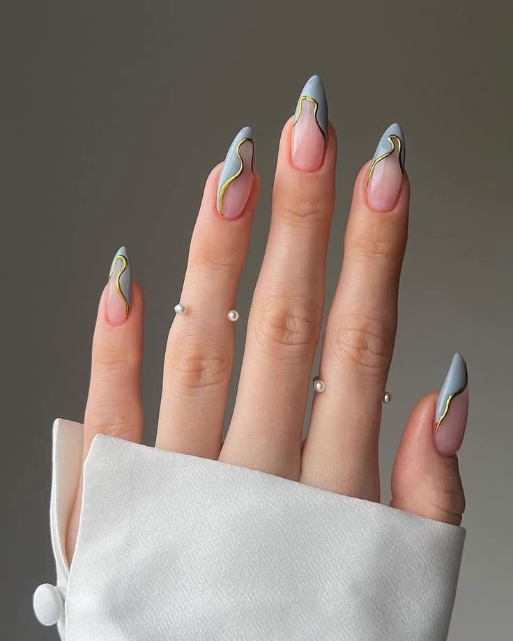 Elegant Pastel Blue Stiletto Nails with Gold Accents for a Modern Look.