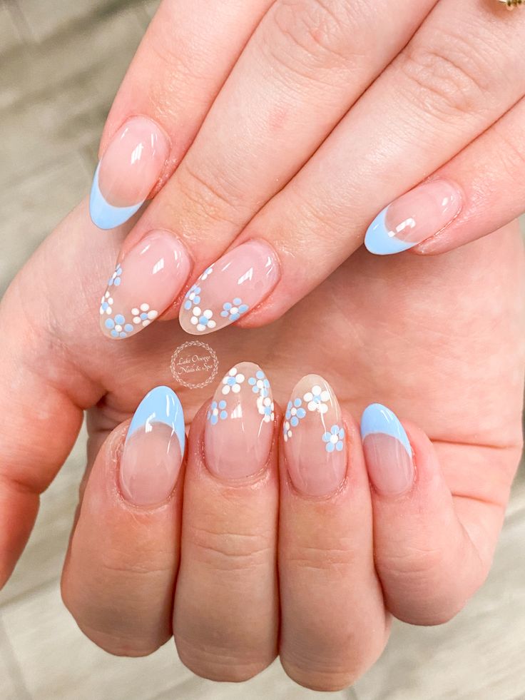 Elegant Floral Nail Design with Light Blue Accents and Nude Base.