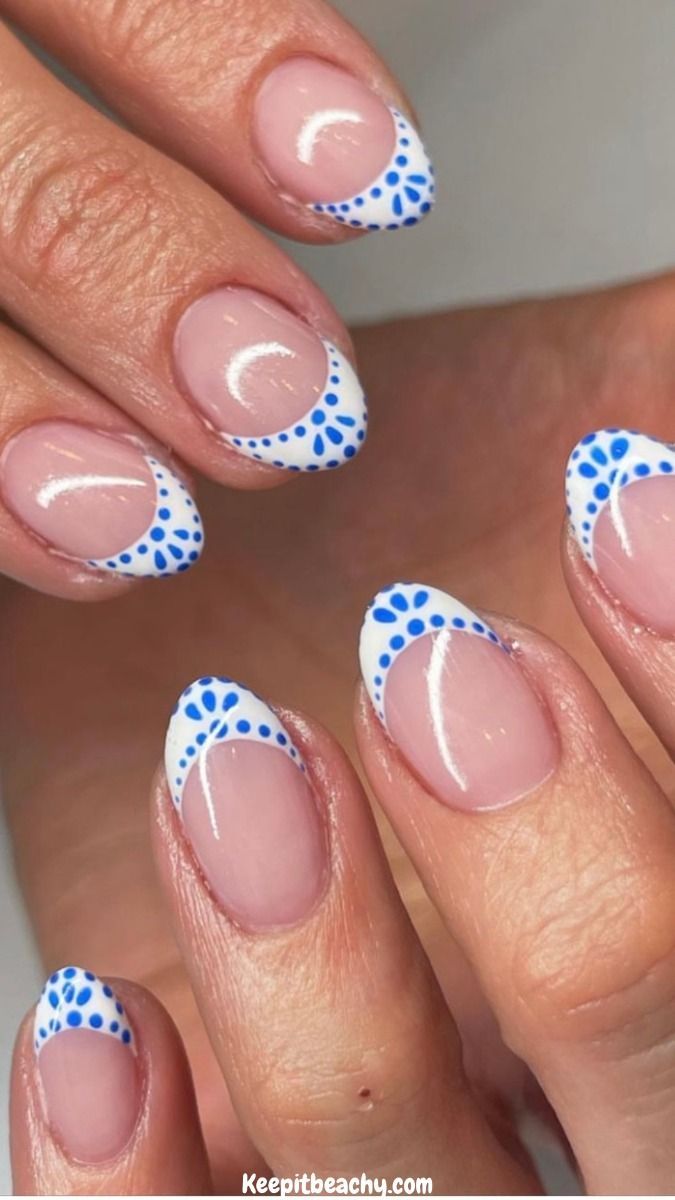 Chic Playful French Tip Nail Design with Vibrant Blue Dots.