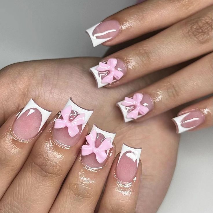 Chic Nail Design: Soft Pink Bows with Striking White French Tips for Elegant Occasions.