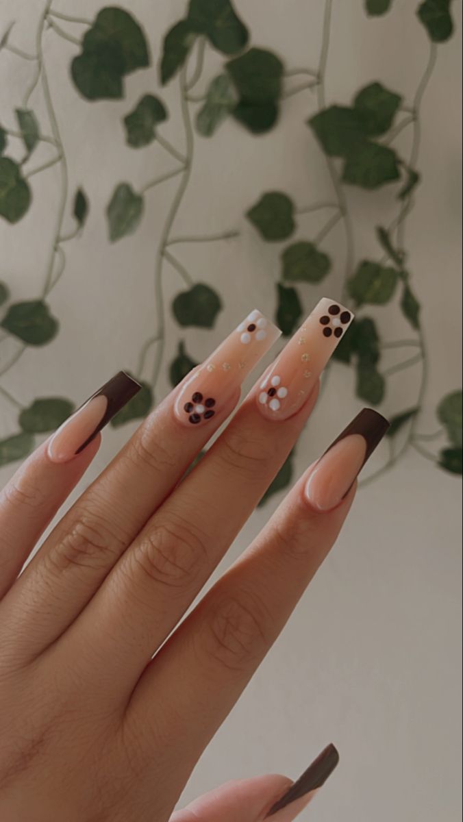 Elegant Long Tip Nail Design with Nude and Brown Shades, Floral Patterns, and Playful Details.