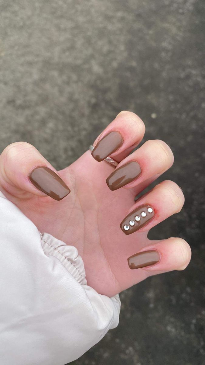 Chic Brown Nails with Glossy Finish and Glamorous Rhinestone Accent.