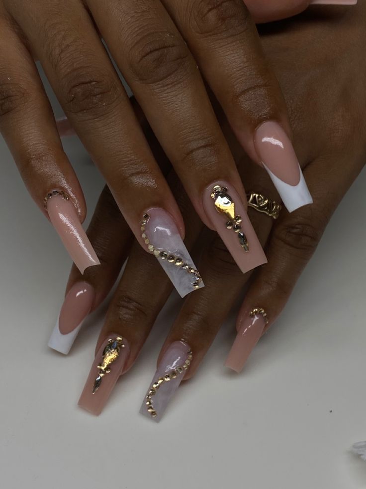 Sophisticated Elegant Nail Design with Nude, White, and Translucent Shades Enhanced by Gold Embellishments.