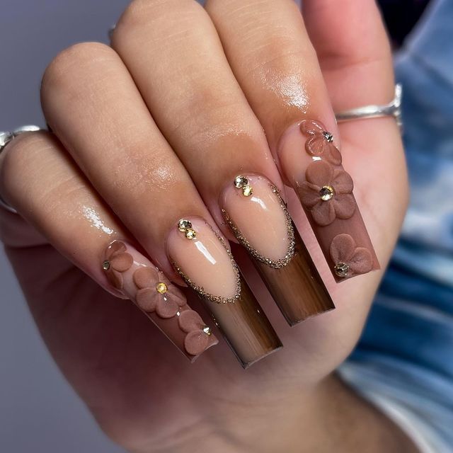 Sophisticated Gradient Nail Art with Floral and Gem Accents.