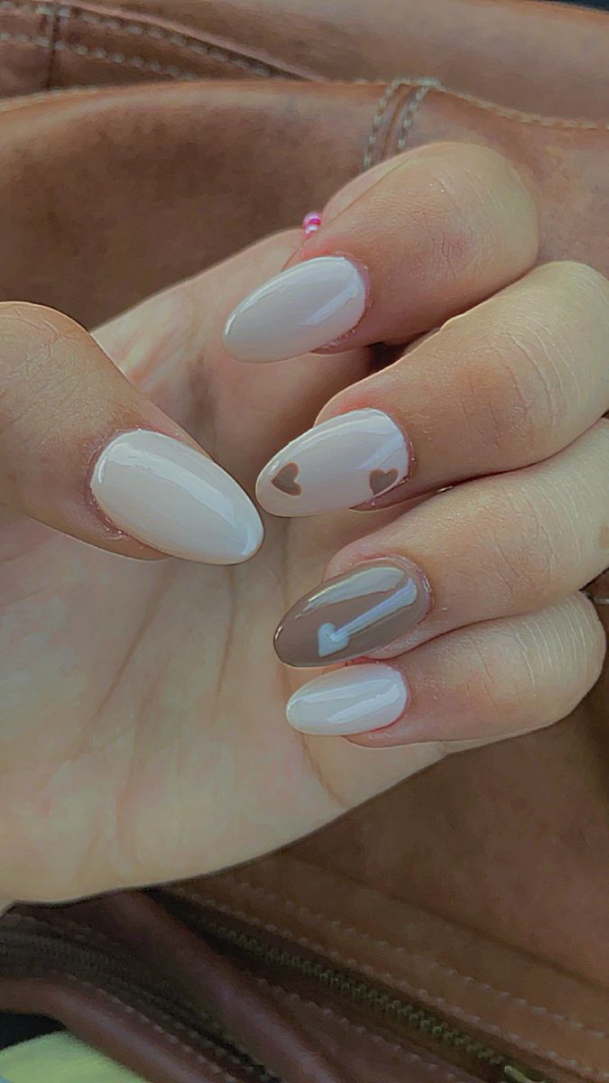 Romantic Whimsical Nail Design in Neutral Tones with Heart Accents.