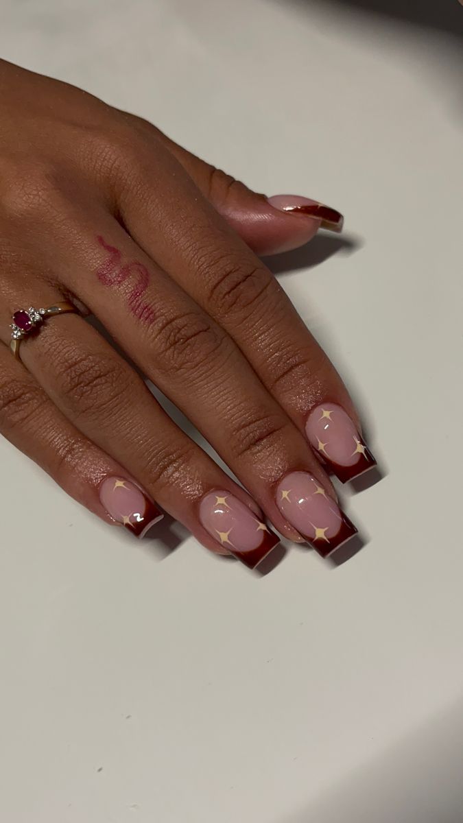 Chic Nail Design: Soft Nude and Burgundy with Gold Star Accents for Any Occasion