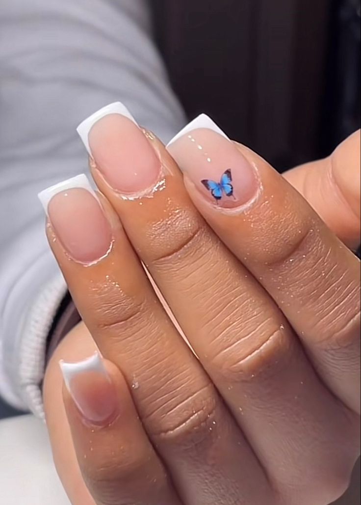 Elegant French Tip Nails Adorned with Playful Butterfly Art.