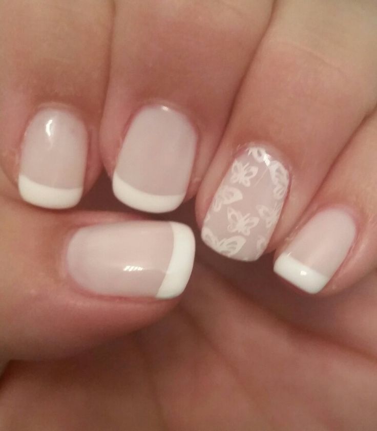 Chic French Tip Nail Design with Delicate Butterfly Motifs.