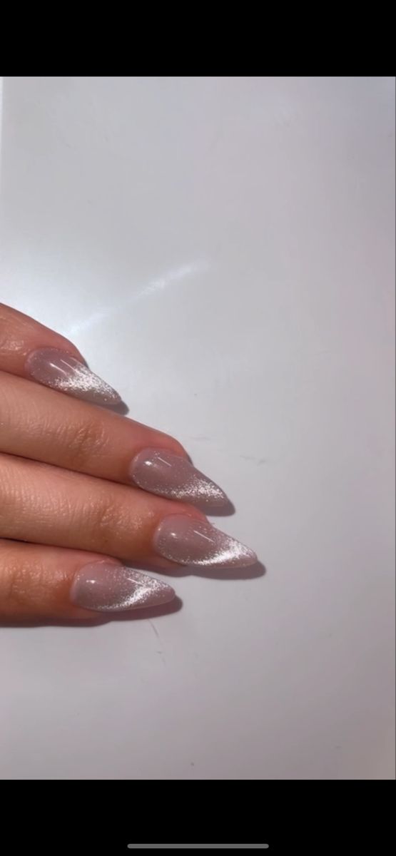 Chic Almond-Shaped Nail Design with Soft Nude and Shimmering White Gradient for Any Occasion.