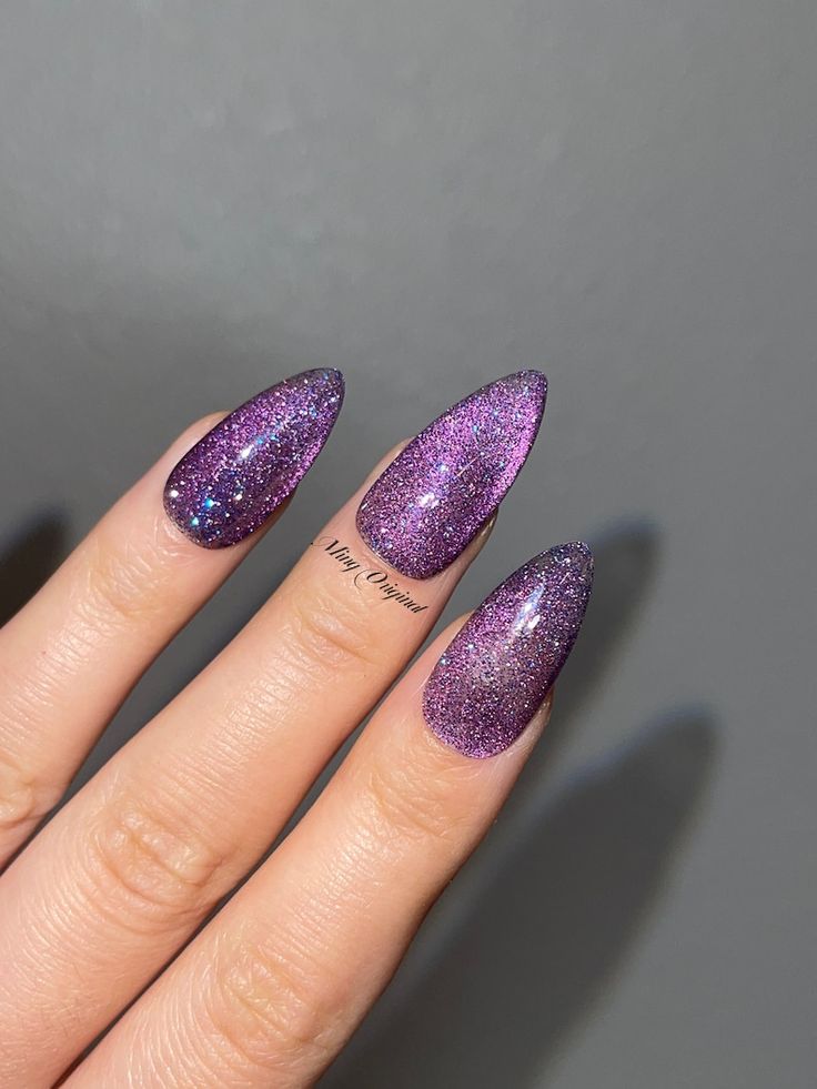 Elegant Sparkly Purple Almond Nails with Stunning Gradient and Glitter Effect.