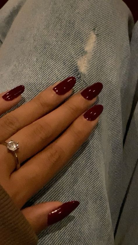 Chic Burgundy Almond Nails: A Sophisticated Accent with Light Denim and Delicate Jewelry.