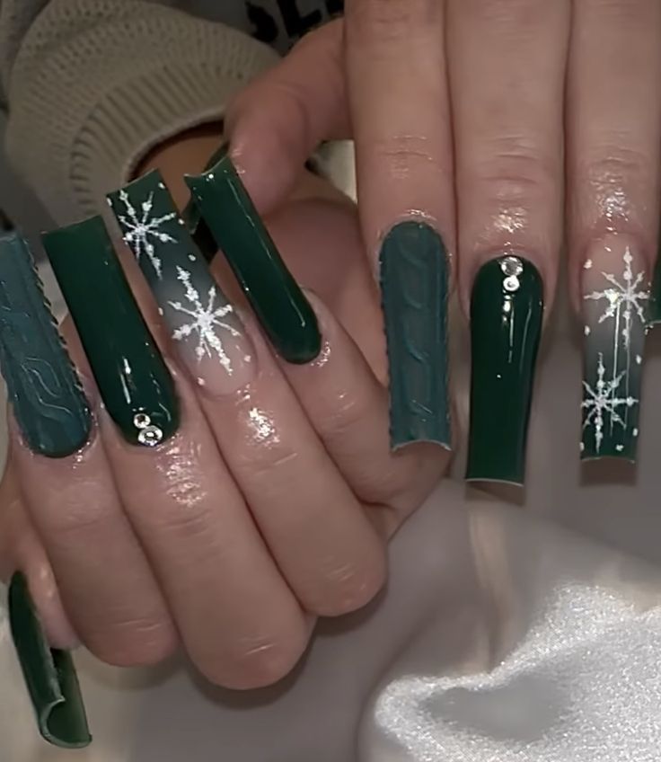 Elegant Winter Nail Design: Rich Green with Snowflake Patterns and Textured Finishes.