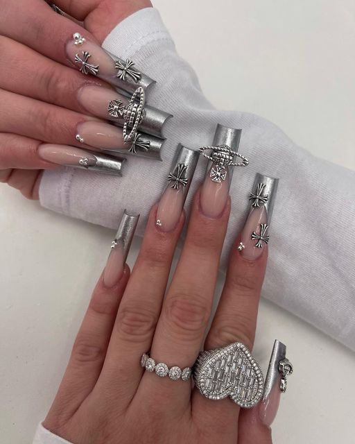 Glamorous Metallic Silver Accented Nail Design with Sculpted Shapes and Rhinestone Embellishments.